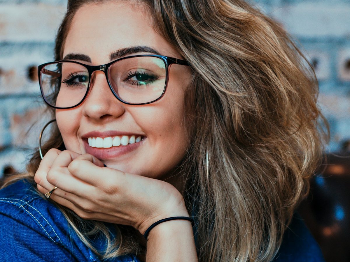 Mulher sorrindo com óculos de grau