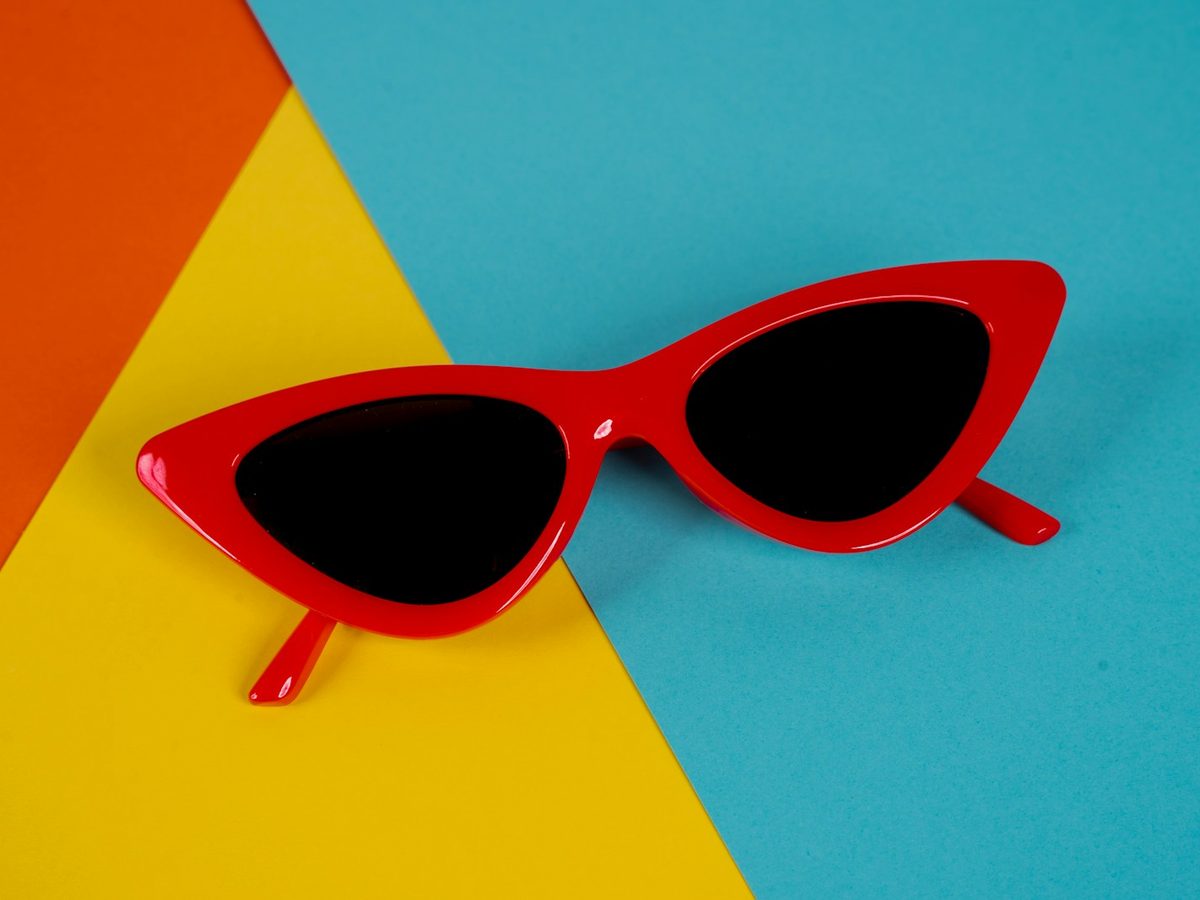 Óculos de sol gatinho vermelho sobre fundo colorido